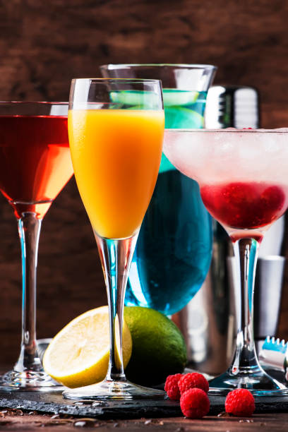 istock Colorful summer cocktails. Cold alcoholic beverages and drinks: mimosa, cosmopolitan, raspberry margarita and blue hawaii on wooden table background with bar tools 1171691113