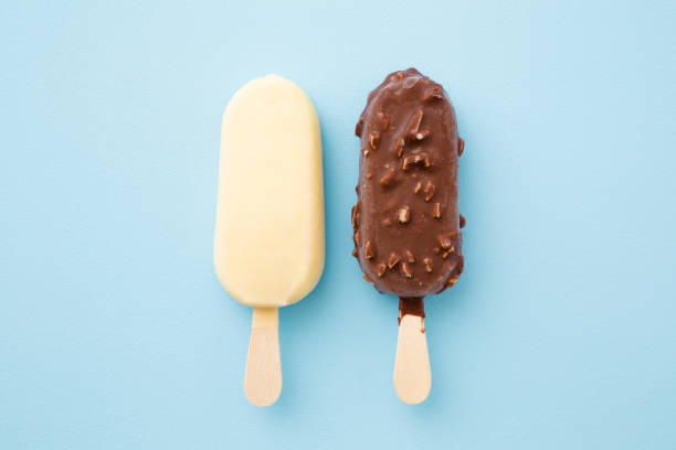 ダークとホワイトのチョコレートグレーズのアイスクリーム2つ。パステルブルーの背景。クローズ アップ。トップビュー。 - chocolate chocolate candy dark chocolate directly above ストックフォトと画像