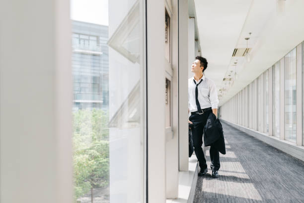 istock Tired businessman standing by the window 1171696211