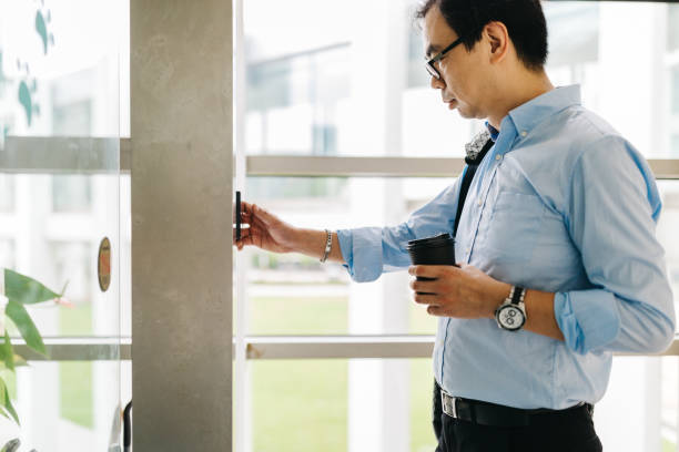 istock Mature Asian businessman entering code on the building entrance. 1171696330
