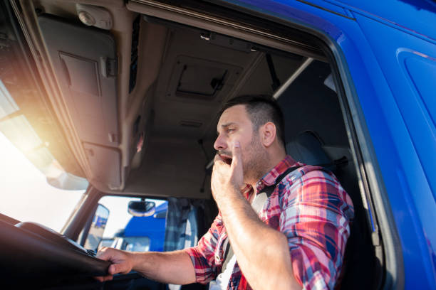 Truck driver yawning while driving. Tired people overworking.