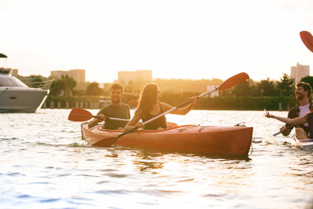 istock Happy friends kayaking on river with sunset on the background 1171698246