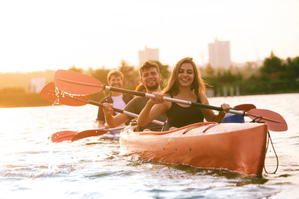 istock Happy friends kayaking on river with sunset on the background 1171698254