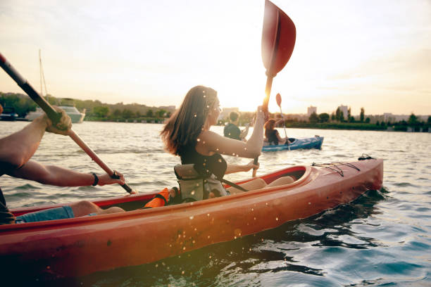 istock Happy friends kayaking on river with sunset on the background 1171698327
