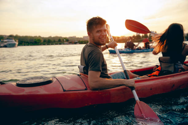 istock Confident young couple kayaking on river together with sunset on the background 1171698430