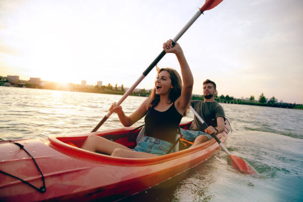 istock Confident young couple kayaking on river together with sunset on the background 1171698431