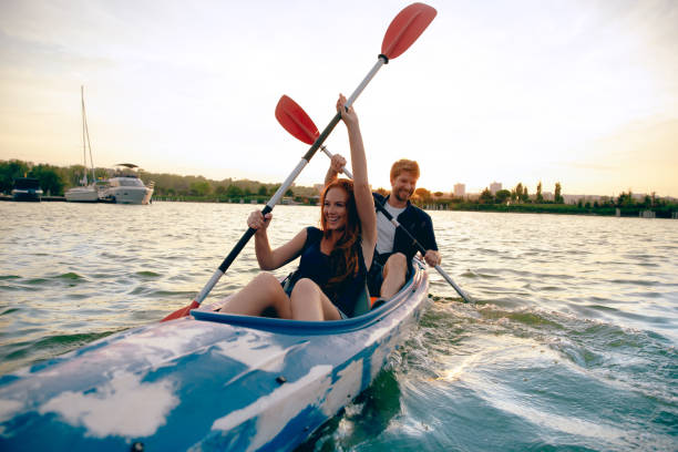istock Confident young couple kayaking on river together with sunset on the background 1171698475