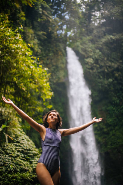 istock Woman looking at the waterfall in jungles 1171700457