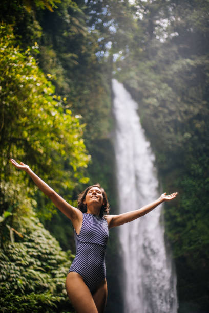 istock Woman looking at the waterfall in jungles 1171700680