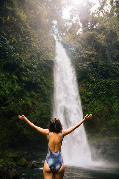 istock Woman looking at the waterfall in jungles 1171701053