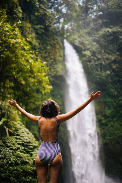istock Woman looking at the waterfall in jungles 1171703010