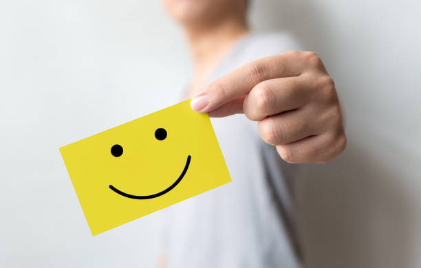 experiencia de servicio al cliente y encuesta de satisfacción empresarial. hombre sosteniendo la tarjeta amarilla con la cara sonriente - emoción positiva fotografías e imágenes de stock