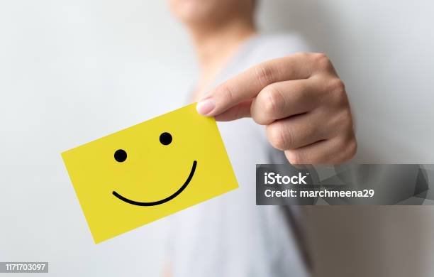 Customer Service Experience And Business Satisfaction Survey Man Holding Yellow Card With Smiley Face Stock Photo - Download Image Now