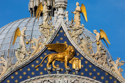 A sculpture of the Lion of Venice, also known as the Lion of St. Mark, on the exterior of St. Mark's Basilica in Venice, Italy.