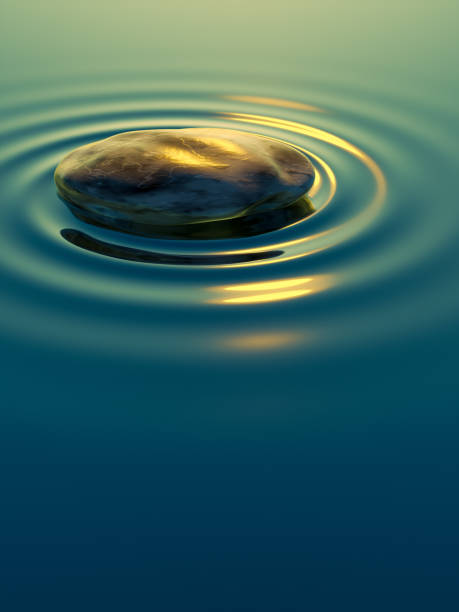 pebble stone in water with ripples background stock photo