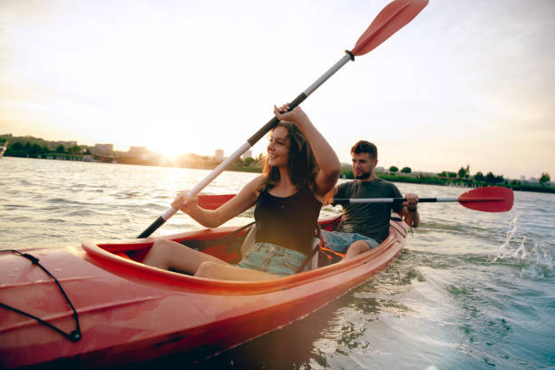 istock Confident young couple kayaking on river together with sunset on the background 1171714001