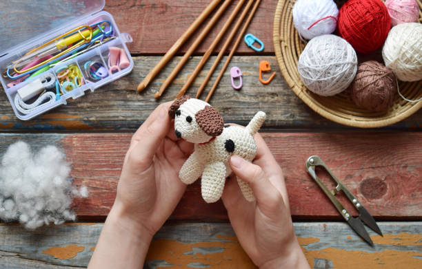 istock Making crochet white dog. Toy for babies or trinket.  On the table threads, needles, hook, cotton yarn. Handmade gift. DIY crafts concept. 1171714006