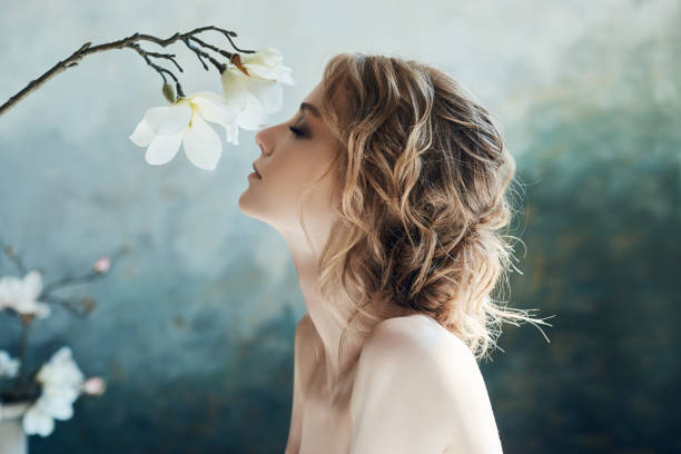 mariée parfaite, portrait d'une fille dans une longue robe blanche. beaux cheveux et peau délicate propre. femme blonde de coiffure de mariage. fille avec une fleur blanche dans ses mains - women spring sensuality fashion model photos et images de collection