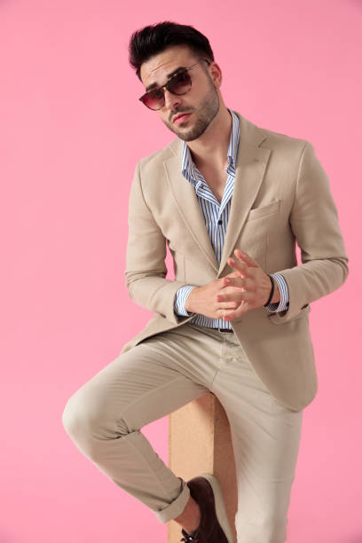 istock smart casual man touching hands seated on a wooden box 1171716774