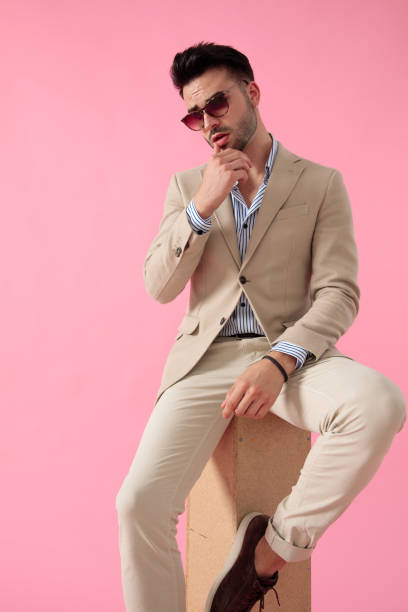 istock smart casual man touching his lips sitting on a wooden box 1171716806