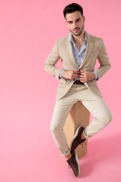 istock smart casual man fixing coat seated on a wooden box 1171716862