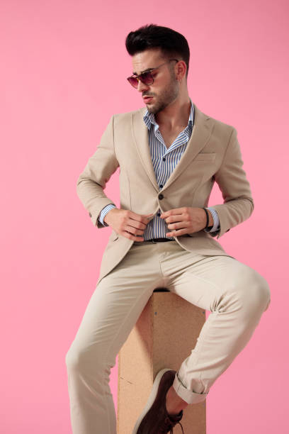 istock attractive young man fixing his coat sitting on a wooden box 1171717043