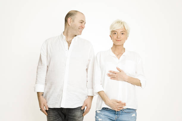 Pregnant woman with her husband over white background