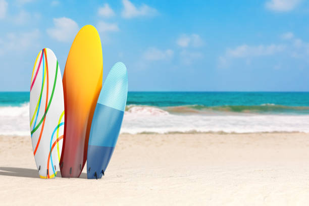 concetto di vacanze estive. tavole da surf estive colorate su una costa deserta dell'oceano. rendering 3d - surfboard foto e immagini stock