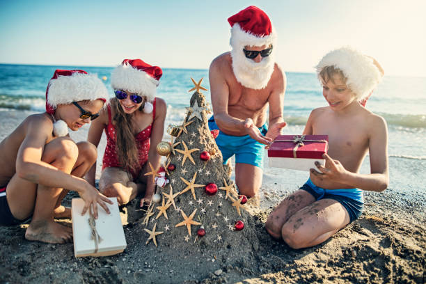 istock Family opening gift under sand Christmas tree. 1171721572