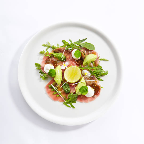 istock Tuna carpaccio with avocado and lime top view 1171721928