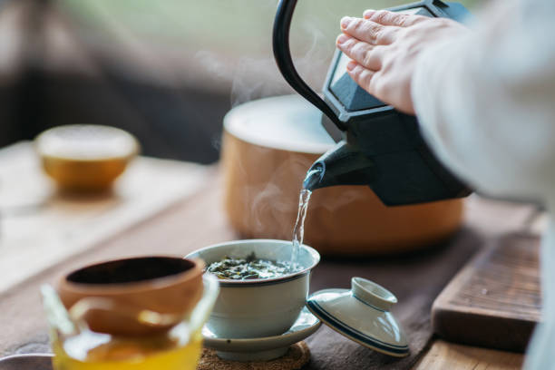 Chinese tea ceremony Woman serving Chinese tea in a tea ceremony. ceremony stock pictures, royalty-free photos & images