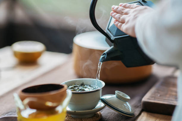 Chinese tea ceremony Woman serving Chinese tea in a tea ceremony. chinese tea stock pictures, royalty-free photos & images