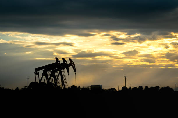 Beam Pump or Donkey Pump in oil field operation - View with dramatic sky