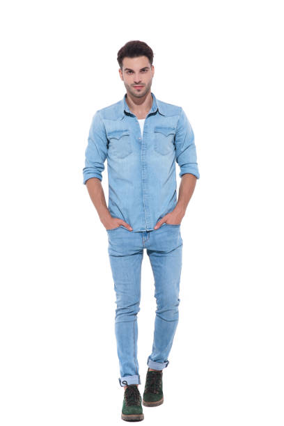 istock relaxed young man walking with hands in his pockets 1171722424