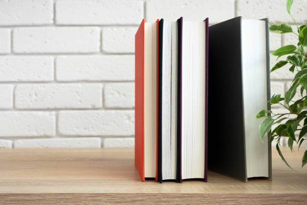 istock Vertical standing group of books on modern shelf in front of white wall 1171722425