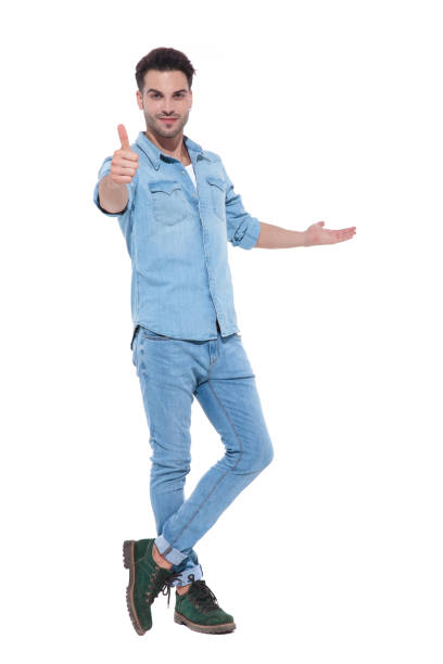 istock handsome man presenting to side and making thumbs up sign 1171722434