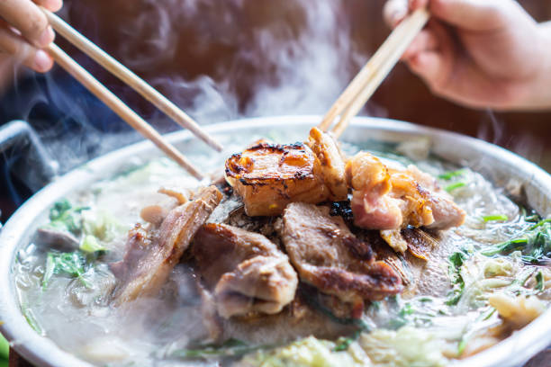 chopsticks da terra arrendada da mão que comem o assado tailandês, alimento popular da rua - adulation asia cooked food - fotografias e filmes do acervo