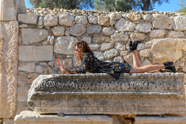 Woman studying book outside.