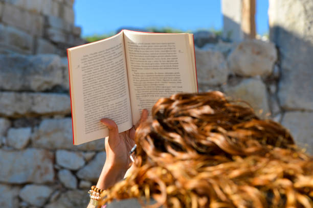 Woman studying book outside.