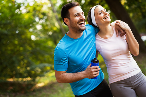 Couple jogging and running outdoors in nature, exercising together