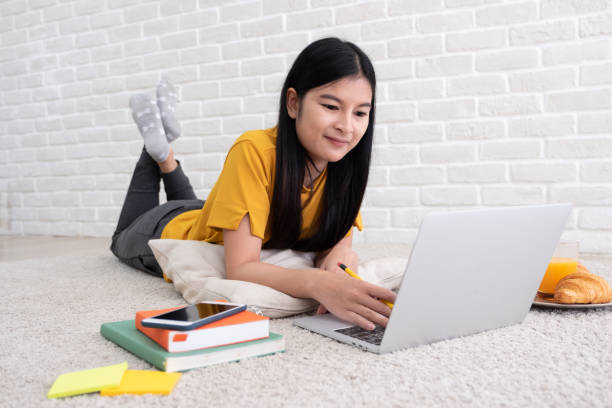 azjatka freelancer pracy na laptopie w home.woman leżącego na dywanie w brick wall.working online stylu życia. - carpet floor lying down people zdjęcia i obrazy z banku zdjęć