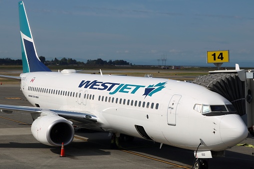 Calgary, Alberta / Canada - August 22, 2019. Closeup of a West Jet Boeing 737-800 commercial airplane at the loading ramp getting ready for a flight at YYC International Airport