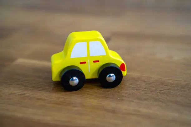Yellow car on wooden table.