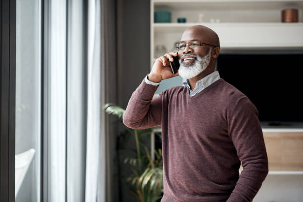 Thank you so much for your help! Cropped shot of a happy senior man standing alone in his living room at home and using his cellphone answering stock pictures, royalty-free photos & images