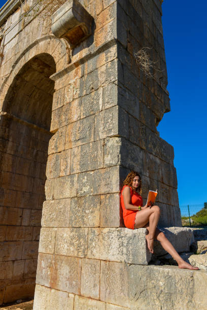 Woman studying book outside.
