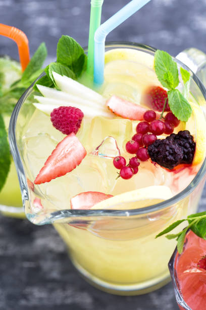 Jug of lemonade with berries top view close up