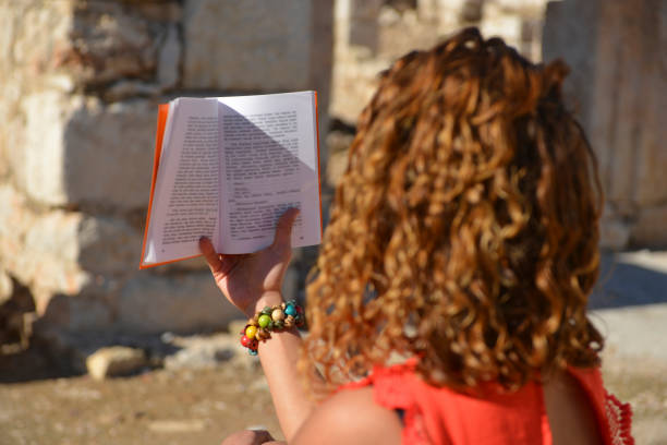 Woman studying book outside.