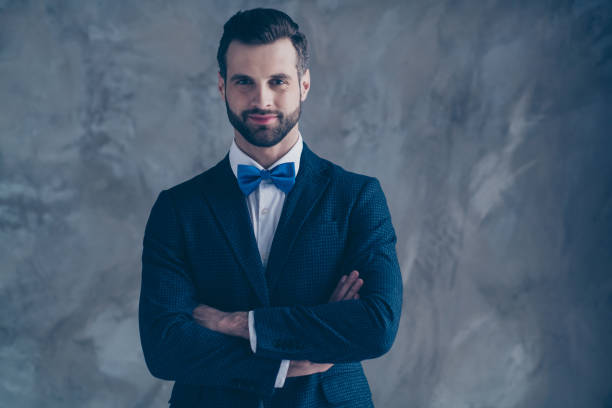 istock Portrait of charming guy crossing his hands looking wearing modern classy bow tie blazer jacket isolated over grey background 1171733426
