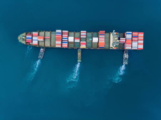 istock Aerial top view Tugboat pushing container ship to quayside for load/unload container via crane for logistics, import export, shipping or transportation. 1171734570