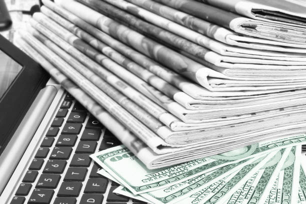 istock Stack of Newspapers, Money and Laptop 1171735058